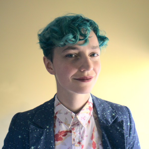 Image of a early-30s girl with green hair, wearing what I think is a pretty cool suit jacket. The girl is me.